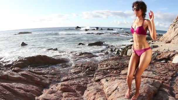 Красива дівчина танцює на пляжі в бікіні на сході сонця — стокове відео