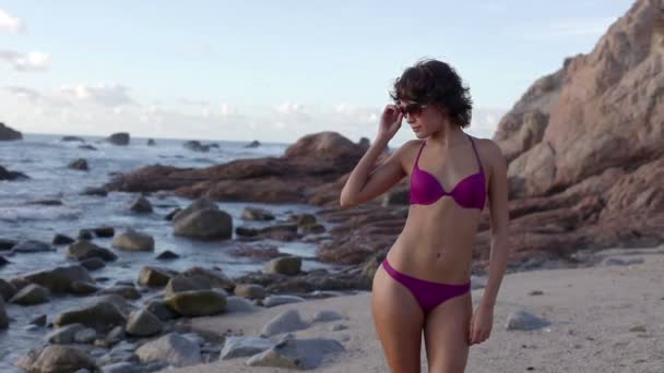 Beautiful girl poses on the beach in a bikini at sunrise — Stock Video