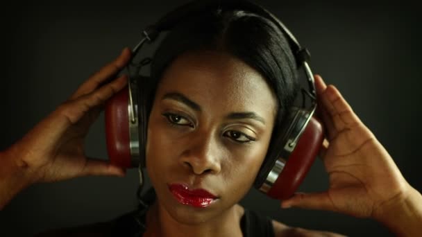 Mujer joven atractiva posando y escuchando música en los auriculares — Vídeos de Stock