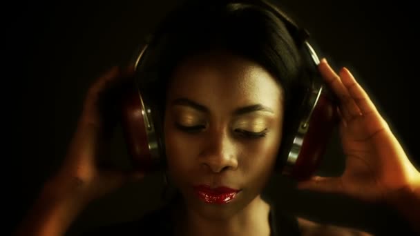 Голова крупным планом сексуальной молодой женщины, слушающей музыку в наушниках — стоковое видео
