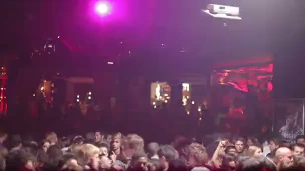 Publiczność tańczyć w nocnym klubie, z głową świateł i laserów — Wideo stockowe