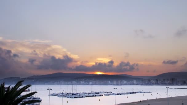 Matahari terbenam di atas pelabuhan di kota pantai palamos — Stok Video