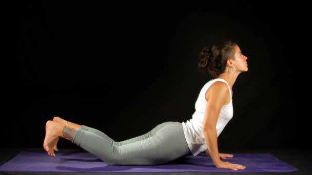 Junge Frau übt Yoga-Bewegungen und Positionen — Stockvideo