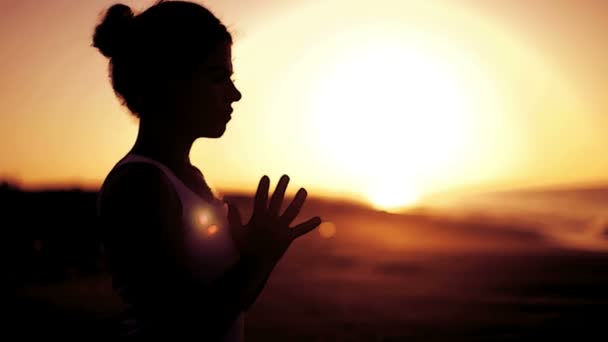 Mujer joven practica yoga en una playa al amanecer — Vídeos de Stock