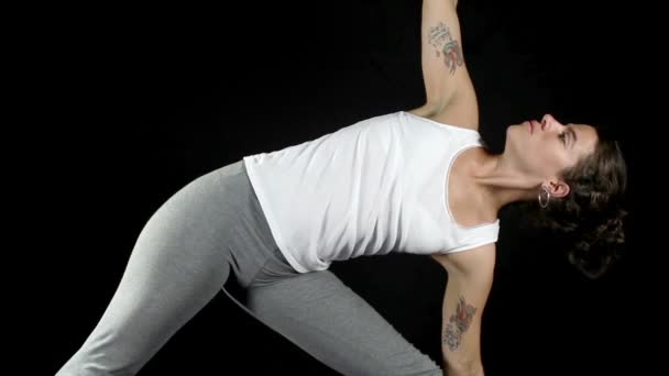 Mujer joven practica movimientos y posturas de yoga — Vídeo de stock