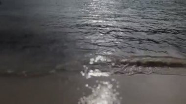 Güneş pırıl pırıl Denizi olarak yavaşça plaj üzerine tur.