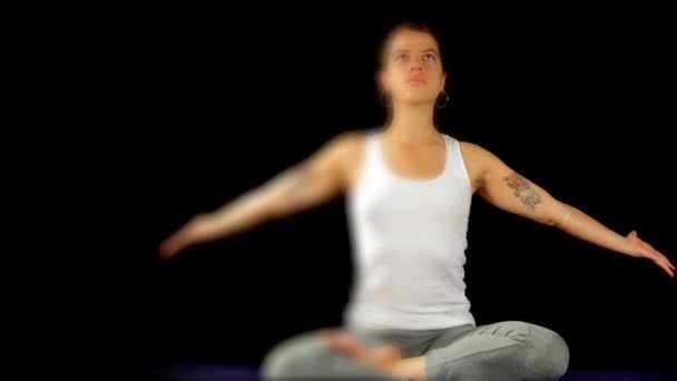Mujer joven practica movimientos y posturas de yoga — Vídeos de Stock