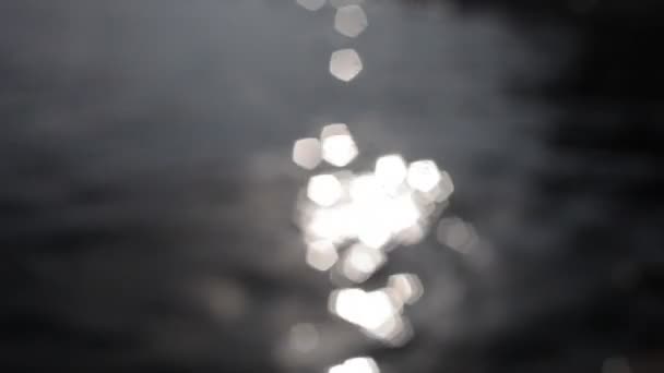 Lumière du soleil scintillant dans la mer comme il tourne doucement sur la plage 