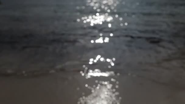 Luz solar cintilante no mar como ele suavemente voltas para a praia — Vídeo de Stock
