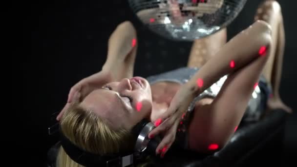 A sexy gogo dancer shot in a studio dancing and posing with a spinning discoball — Stock Video