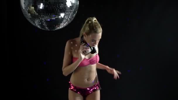 A sexy gogo dancer shot in a studio dancing and posing with a spinning discoball — Stock Video