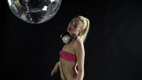 A sexy gogo dancer shot in a studio dancing and posing with a spinning discoball — Stock Video