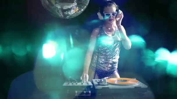 Um dj feminino sexy dançando e tocando discos com fundo estilo disco — Vídeo de Stock