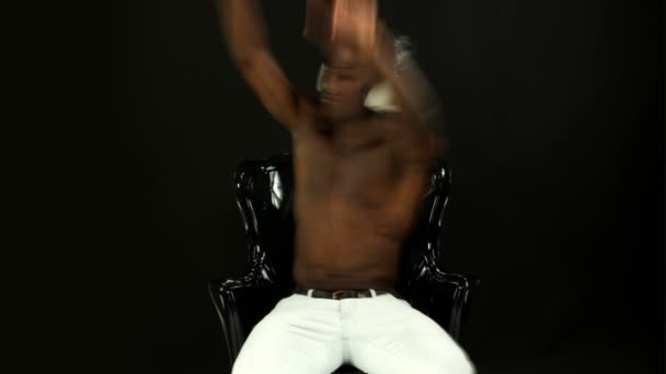 Supercooler junger Kerl sitzt auf einem Stuhl und hört Musik — Stockvideo