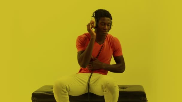 Super cool young guy dances and poses with headphones — Stock Video