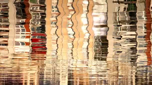 Reflet des bâtiments colorés et des bateaux dans l'eau avec des ondulations — Video