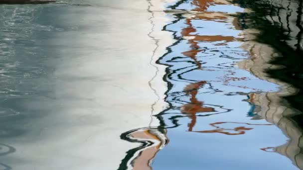 Reflektion av färgglada byggnader och båtar i vattnet med ringar — Stockvideo