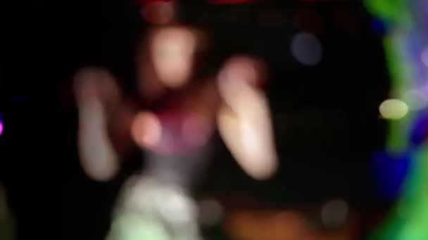 Una donna sexy balla fuori fuoco con luci da discoteca — Video Stock
