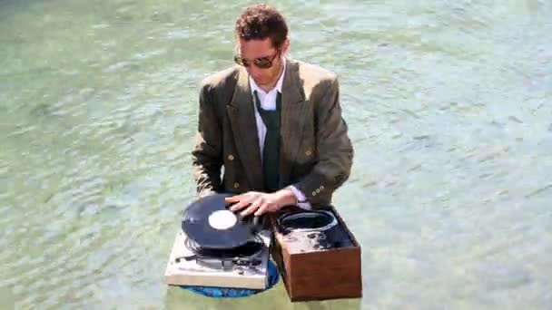 Funky dj σε ένα κοστούμι που παίζει στη θάλασσα — Αρχείο Βίντεο