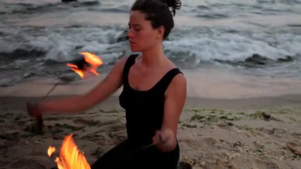 Uma mulher faz uma performance de fogo na praia — Vídeo de Stock