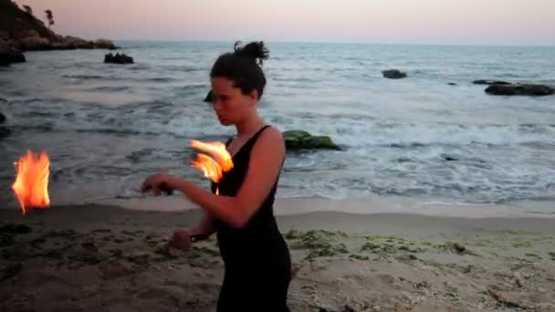 Una mujer hace una actuación de fuego en la playa — Vídeos de Stock