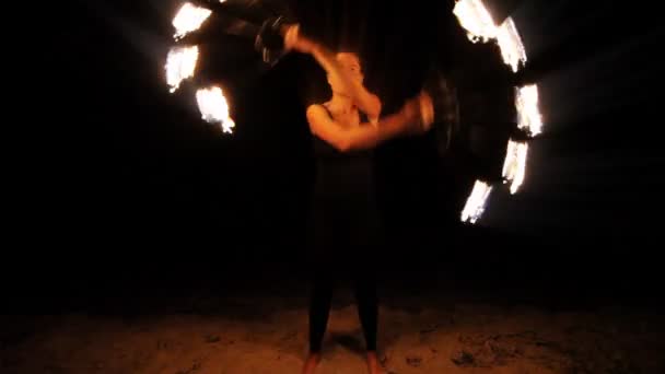 Uma mulher faz uma performance de fogo na praia — Vídeo de Stock