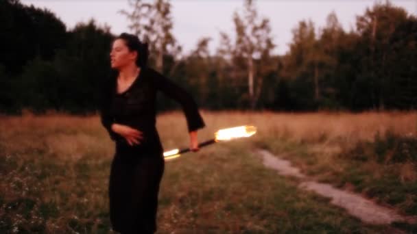 Une femme fait un spectacle de feu sur la plage — Video