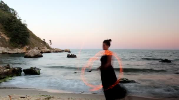 A woman does a fire performance on the beach — Stock Video