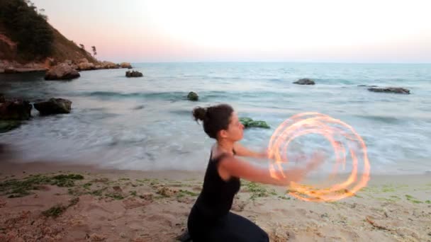 Una mujer hace una actuación de fuego en la playa — Vídeo de stock