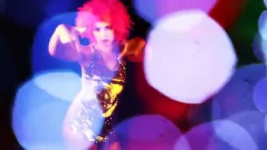 seksi bir kadın pembe çılgın saç modeli ile dans ediyor.