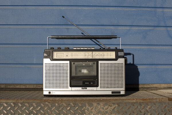 A vintage transistor radio sitting outside on a wall