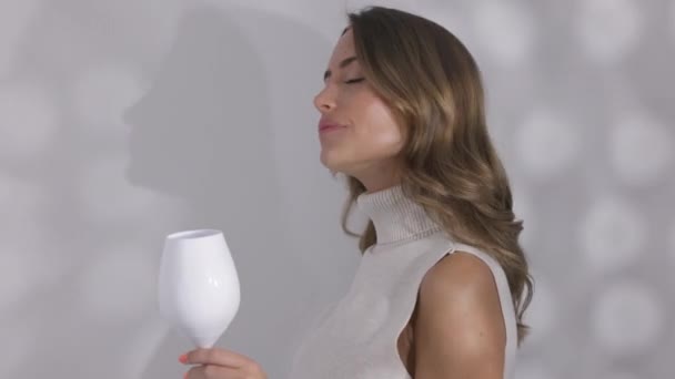 Женщина позирует с бокалом белого вина — стоковое видео
