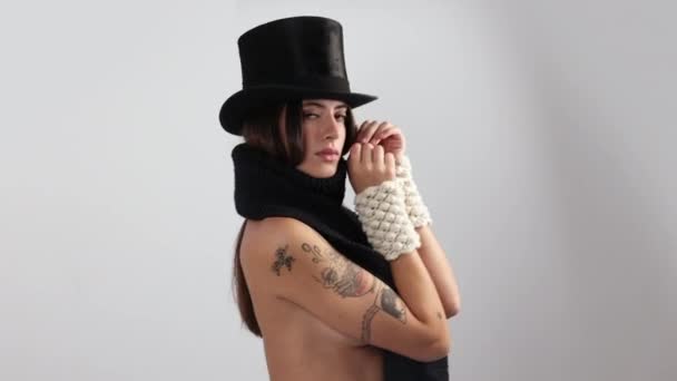 Жінка позує і танцює в трикотажному капелюсі і шарфі — стокове відео