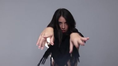 Kadın örgü eşarpla poz veriyor ve dans ediyor.