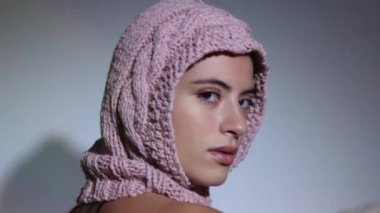 Kadın örgü şapkayla poz veriyor ve dans ediyor. 