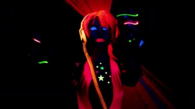 Parlak UV kostümlü kadın dansçı.