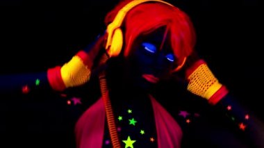 Parlak UV kostümlü kadın dansçı.