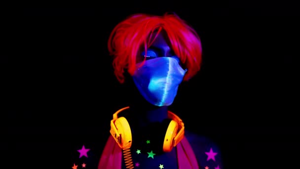 Жіночі танці в світлому ультрафіолетовому костюмі та масці — стокове відео