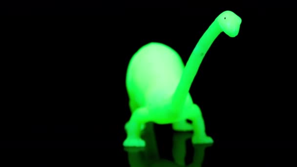 Groen speelgoed dinosaurus draaien agaisnt zwart — Stockvideo