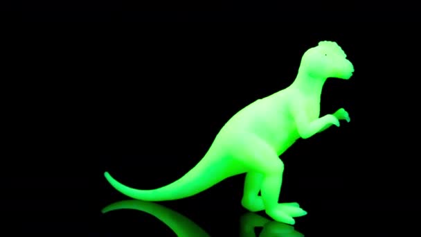 Groen speelgoed dinosaurus draaien agaisnt zwart — Stockvideo