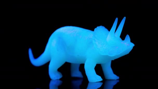 Зелений іграшковий динозавр перетворюється на чорний — стокове відео