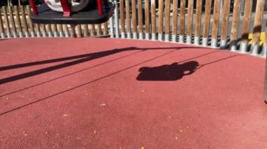 Salıncaktaki küçük çocuğun gölgesi