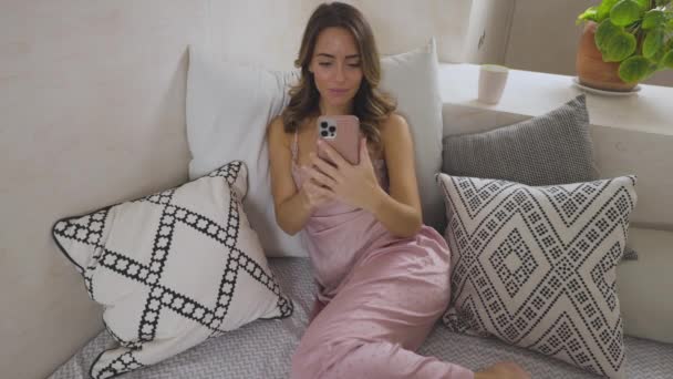 女性でパジャマオン彼女のベッド — ストック動画