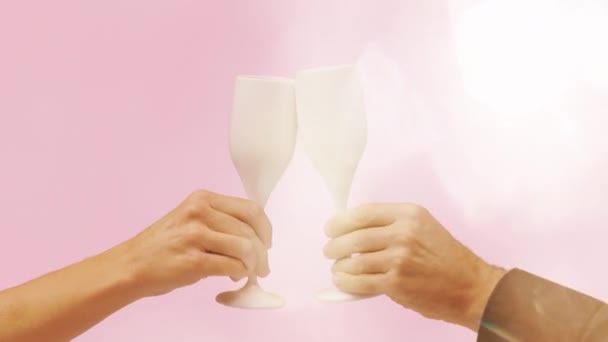 Witte champagne glazen maken gejuich tegen roze — Stockvideo