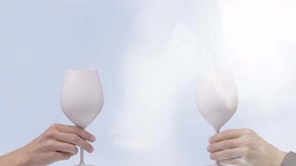 Wine glasses making cheers against pale blue — Stock Video