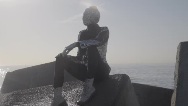 반짝이는 얼굴로 바위에 앉아 있는 디스코 맨 — 비디오