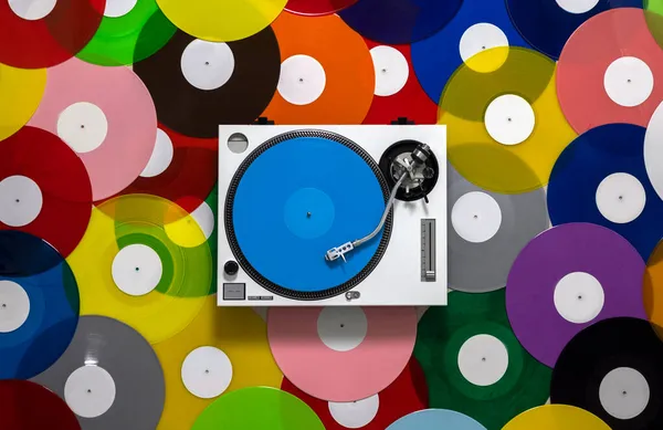 Gira-discos DJ com diferentes discos coloridos — Fotografia de Stock