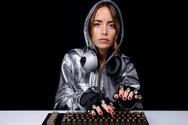 Женщина в серебряном костюме печатает на клавиатуре — стоковое фото