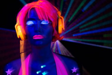 Parlak UV kostümlü kadın dansçı.