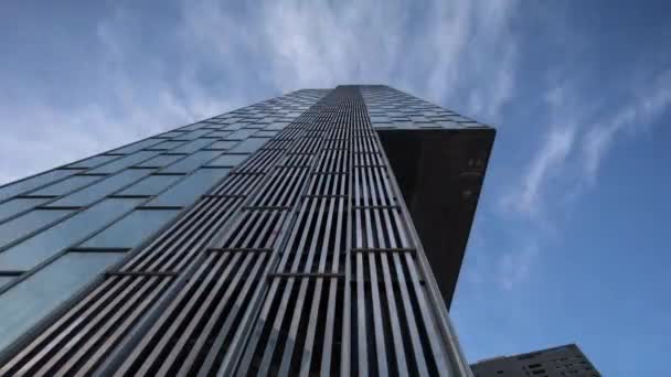 Σύννεφα που περνούν πάνω από γυάλινο ουρανοξύστη — Αρχείο Βίντεο